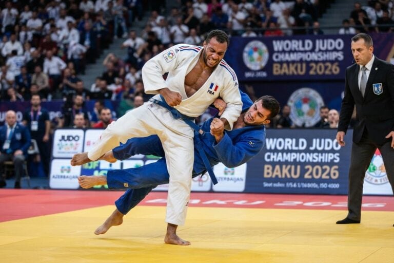 Un judoka en kimono blanc aux couleurs de la France projette son adversaire en bleu devant l'arbitre, à Bakou